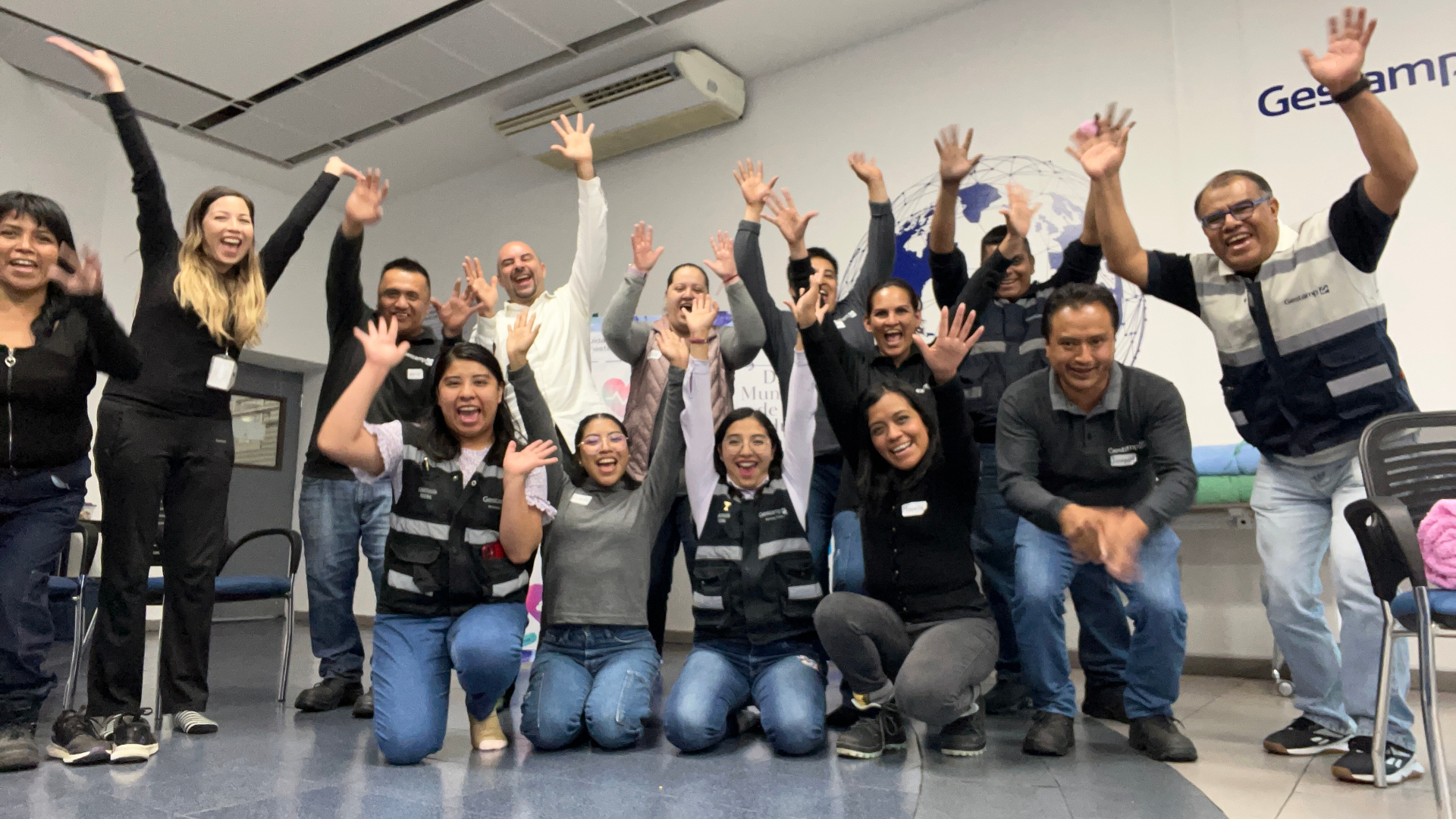 Equipo de Gestamp celebrando con las manos arriba en una sesión de risoterapia
